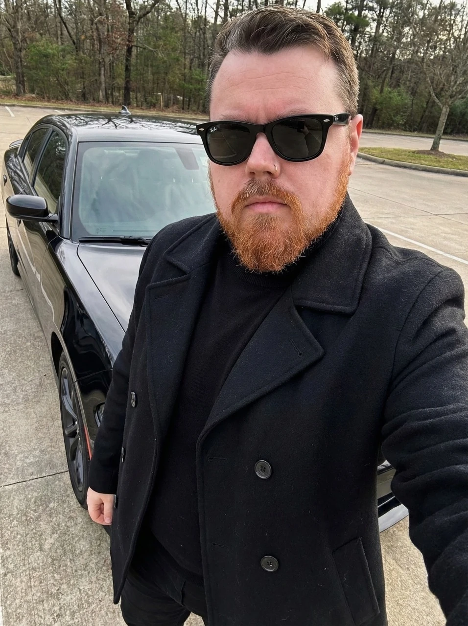 Shane Lint, founder and editor of The Oakmoss & Ivy, wearing a black pea coat and sunglasses
